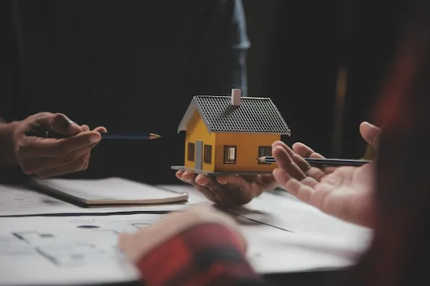 A model house held between two people discussing plans and blueprints